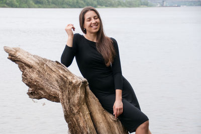 Young woman smiling while standing on shore