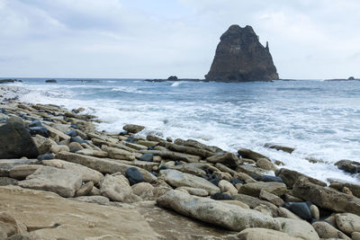 Scenic view of rocks in sea against sky