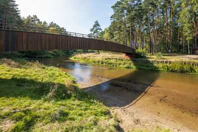 A footbridge with a wooden balustrade over the beautiful mala panew river. zawadzkie, poland