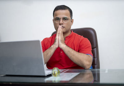 Mid adult man using mobile phone while sitting on table