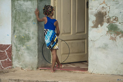 Young woman standing against blue wall