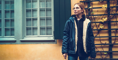 Portrait of a woman standing against wall