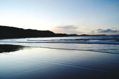 Scenic view of beach against sky during sunset