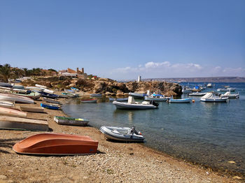 Boats moored on sea against clear sky