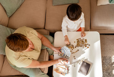 Boy using digital tablet while sitting on sofa at home