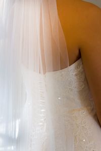 Midsection of bride in wedding dress