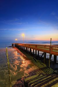 Pier over sea against sky at sunset