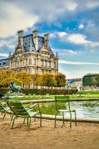 Benches in city against sky