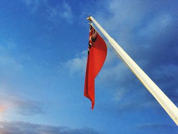 Low angle view of flag against blue sky