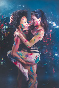 Young women wearing bikini while covered in body paint at nightclub