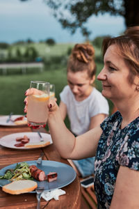 Family having a meal from grill during summer picnic outdoor dinner in a home garden