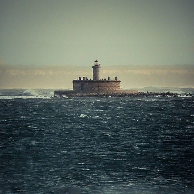 sea, lighthouse, water, architecture, built structure, building exterior, guidance, horizon over water, direction, tower, protection, waterfront, safety, sky, clear sky, copy space, security, tranquility, scenics, tranquil scene