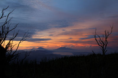 Scenic view of silhouette mountains against sky at sunset