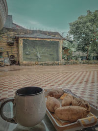 Coffee cup on table against building