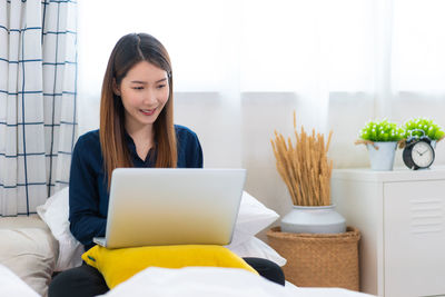 Young woman using laptop at home