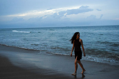 Full length of man standing on beach against sky