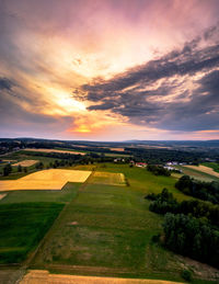 Scenic view of agricultural field against sky during sunset