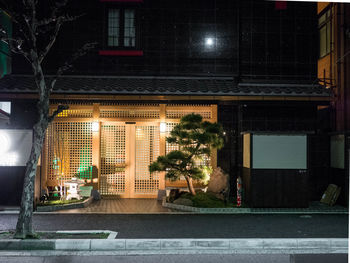 Illuminated building by street at night