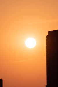 Silhouette buildings against sky during sunset