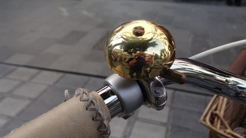 Reflection of man photographing on bicycle bell