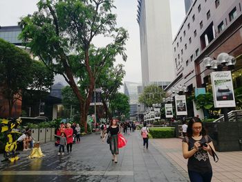 People on street amidst buildings in city