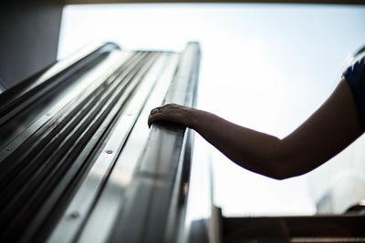 Cropped hand of woman holding escalator railing