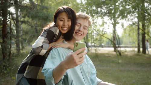 Happy couple taking selfie at park