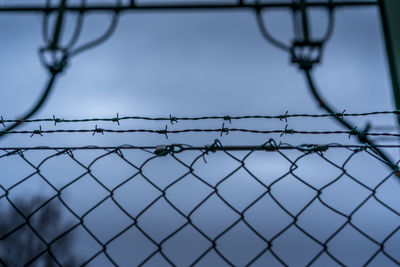 Close-up of barbed wire fence against clear sky