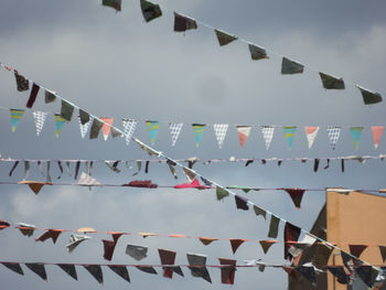 Low angle view of flags hanging against sky