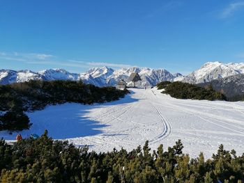 Scenic view of snowcapped mountains against blue sky