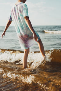 Girl spending a free time enjoying the sea and a beach at sunset during summer vacation