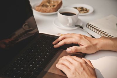 Midsection of man using laptop