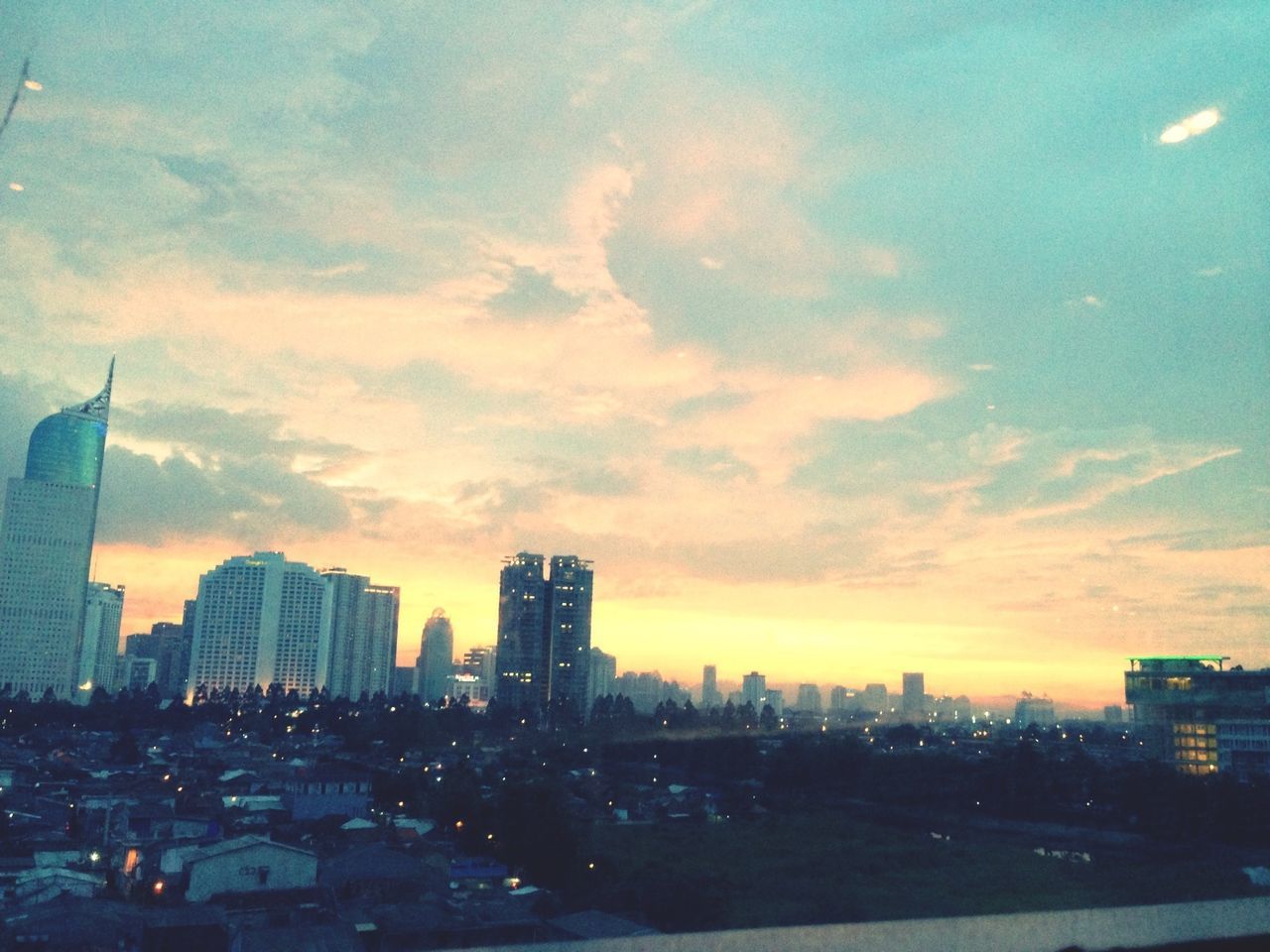 building exterior, city, architecture, built structure, sky, cityscape, sunset, skyscraper, cloud - sky, urban skyline, dusk, office building, modern, city life, illuminated, cloud, tall - high, cloudy, silhouette, building