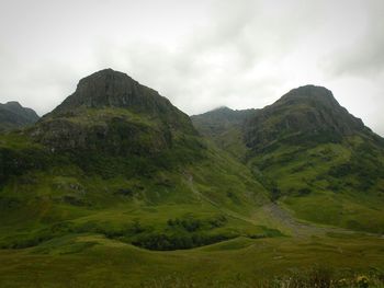 Scenic view of mountains against cloudy sky