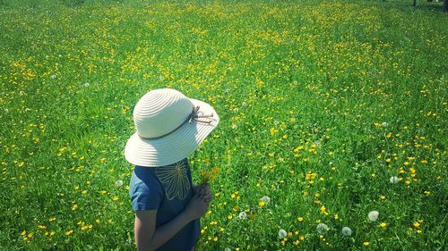 Rear view of woman wearing hat on field