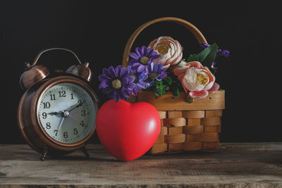 Close-up of clock on table against black background