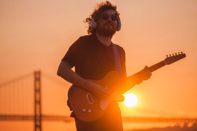 Side view of man playing guitar