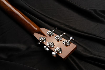 Cropped image of guitar on bed