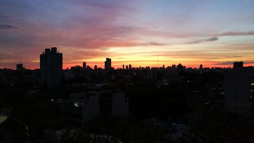 Silhouette buildings against sky during sunset