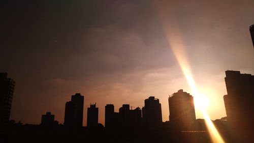 Silhouette buildings against sky during sunset