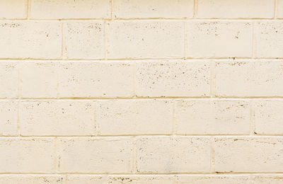 Freshly painted wall structure made of light beige foam concrete blocks, texture of wall