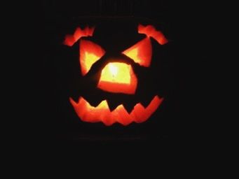 Close-up of lit candle in dark room