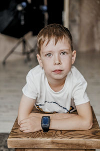 Young little caucasian child with green eyes in a white t-shirt, with a wrist watch