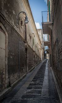 Alley amidst buildings against sky