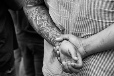 Midsection of couple holding hands