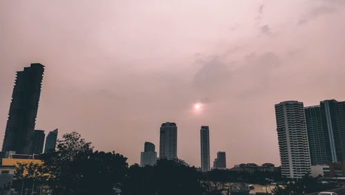 Modern buildings against sky during sunset