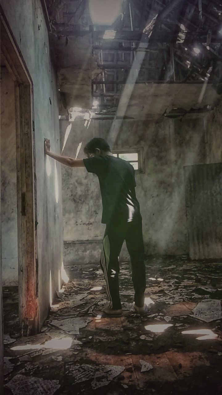 FULL LENGTH OF MAN STANDING IN ABANDONED BUILDING