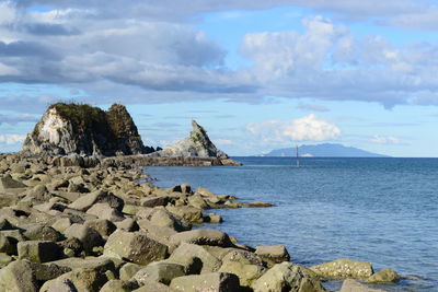 Rocks on sea shore against sky