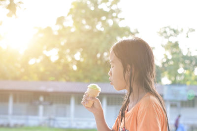 Portrait of a young woman drinking glass outdoors