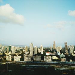View of cityscape against cloudy sky